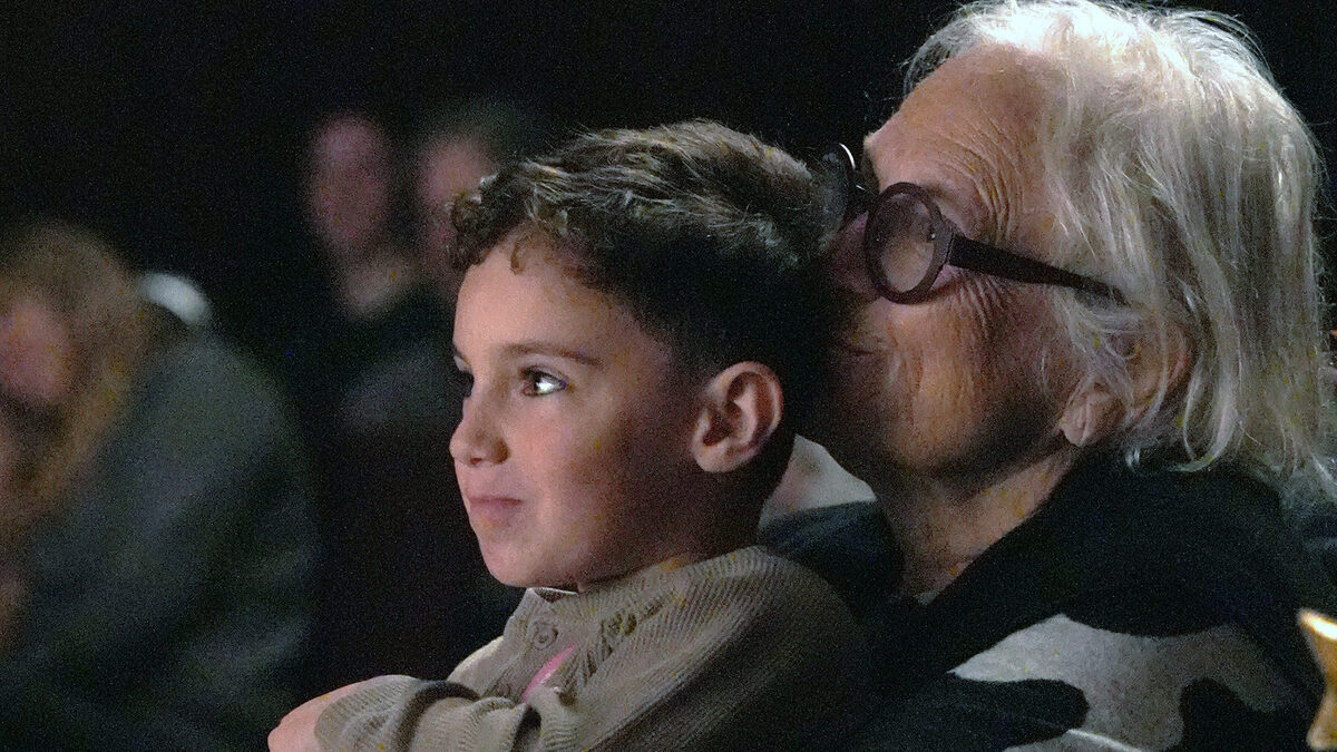 A young child watches the stage wide-eyed from a grandmother's lap in the audience at a Vital Theatre Company show in NYC