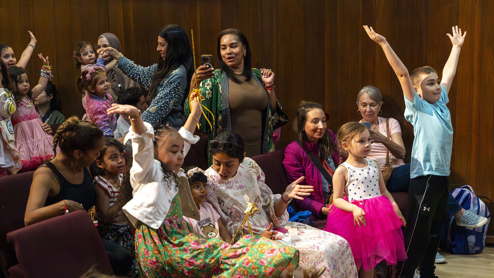 Children and parents cheer with the cast in costume during a post-show meet-and-greet at a Vital Theatre Company show in NYC
